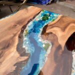 Close-up view of the epoxy resin detail on the Sylva Home custom black walnut epoxy ocean dining table, model ET38.