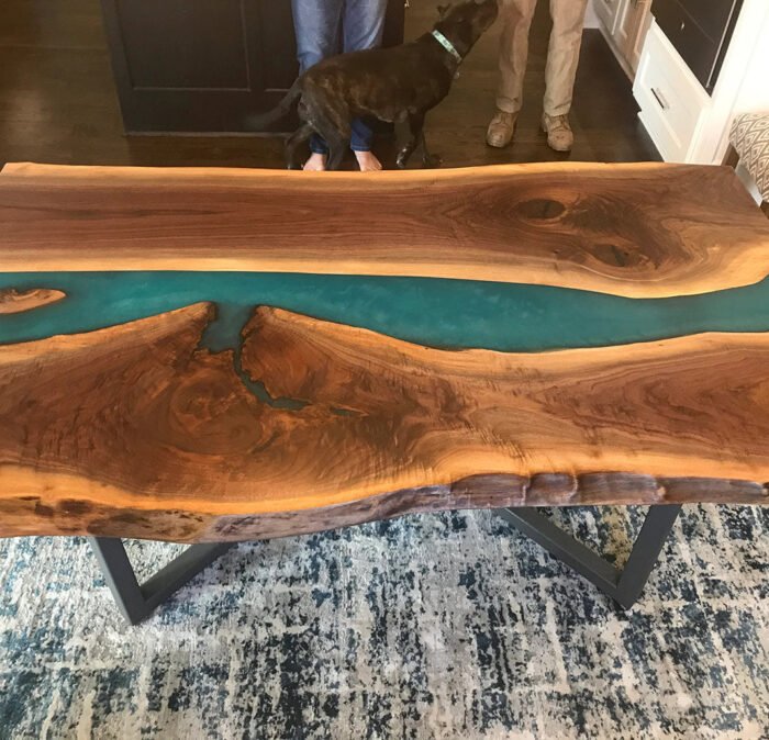 Angled view of the Sylva Home custom black walnut epoxy resin blue river table, model ET11, showing the table’s depth and texture.