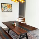 Side view of the Sylva Home custom black walnut slab epoxy river table, model ET36, showcasing the table's edge and legs.