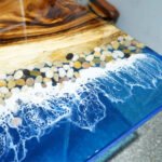 View of the ocean wave pattern created by the epoxy resin on the Sylva Home custom ocean wave walnut epoxy dining table, model ET24.