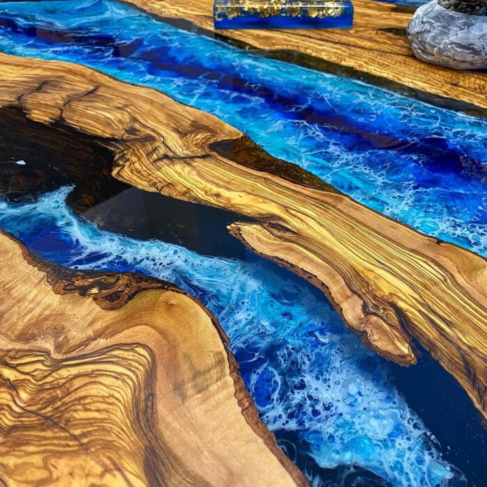 Close-up view of the epoxy resin detail on the Sylva Home custom olive wood epoxy ocean wave dining table, model ET45.