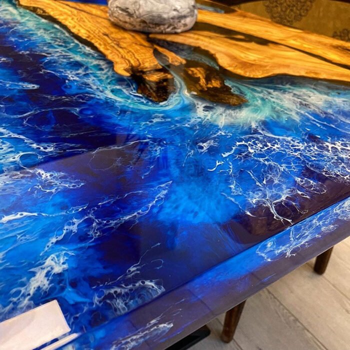 View of the ocean wave pattern created by the epoxy resin on the Sylva Home custom olive wood epoxy ocean wave dining table, model ET45.