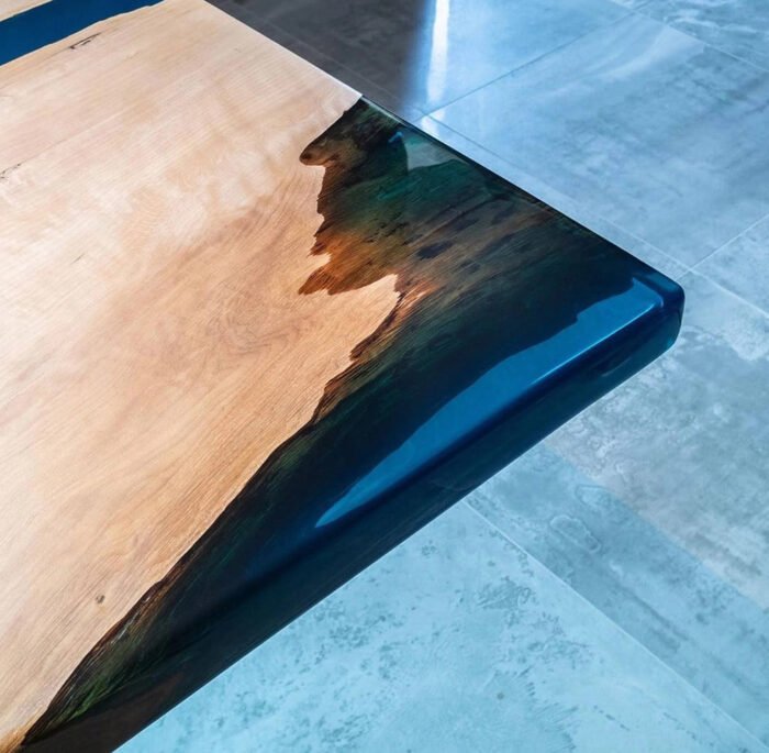 Close-up view of the blue epoxy resin detail on the Sylva Home custom walnut river table, model ET32.