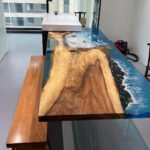 Full view of the Sylva Home custom walnut epoxy ocean table, model ET29, highlighting its design and finish.