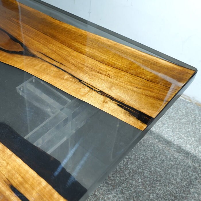 Close-up view of the epoxy resin detail on the Sylva Home custom walnut epoxy resin live edge dining table, model ET23.