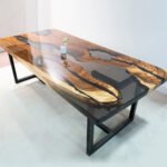 Angled view of the Sylva Home custom walnut epoxy resin river table, model ET1, showing the table's depth and texture.