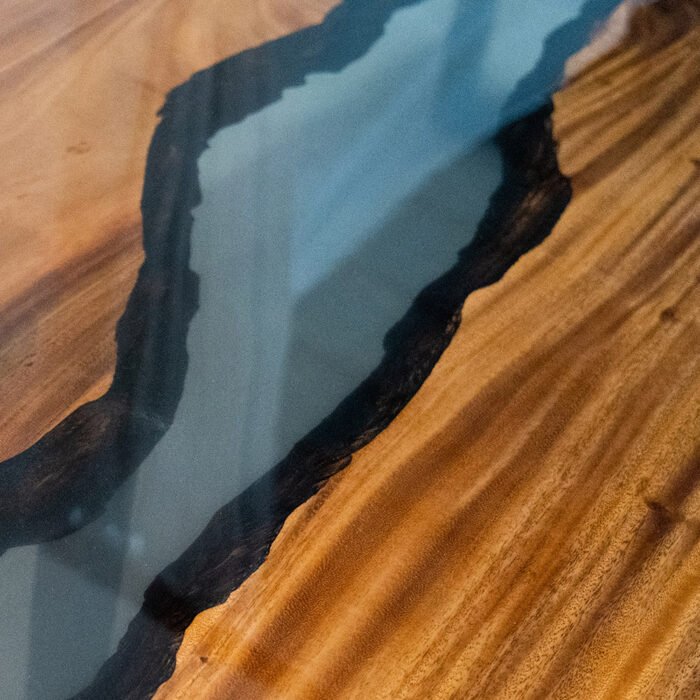 Close-up view of the epoxy resin detail on the Sylva Home custom walnut river table, model ET1.