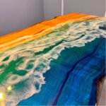 View of the ocean pattern created by the epoxy resin on the Sylva Home custom walnut wood dining epoxy ocean table, model ET49.