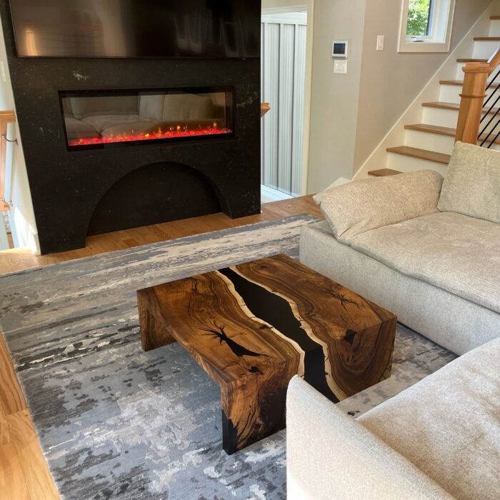 Side view of the Sylva Home custom black walnut epoxy waterfall table, model ET63, showcasing the table's edge and legs.