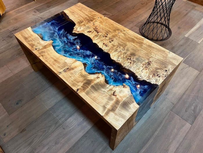 Angled view of the Sylva Home custom epoxy blue river waterfall table, model ET62, showcasing its overall aesthetic.