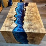 Side view of the Sylva Home custom epoxy blue river waterfall table, model ET62, showcasing the table's edge and legs.