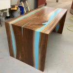 Angled view of the Sylva Home custom epoxy resin waterfall river table, model ET66, showcasing its overall aesthetic.