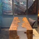 Side view of the Sylva Home custom walnut epoxy waterfall table, model ET61, showcasing the table's edge and legs.